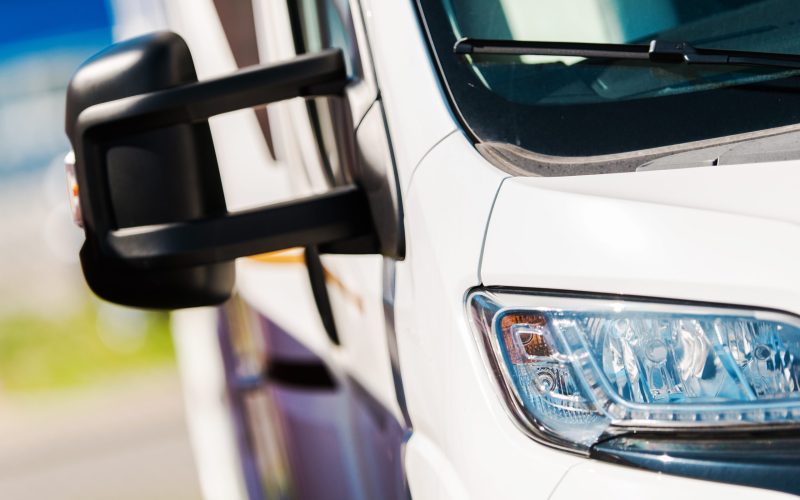 Modern Camper Van Closeup. Motorhome Wide Mirrors Concept. Vacation Road Trip.